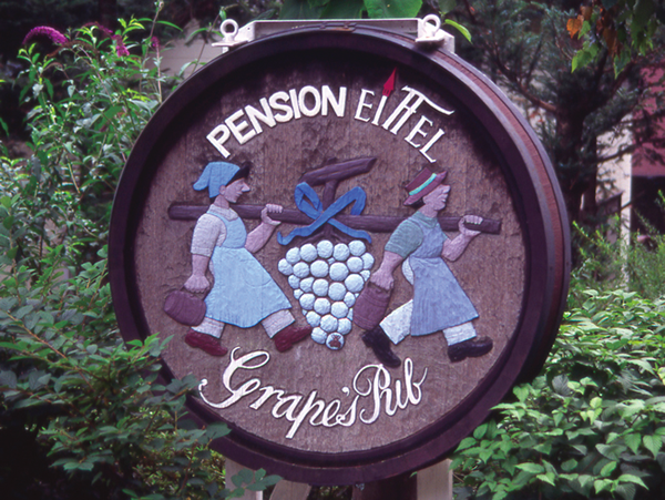 山梨県大泉村にあるペンションの看板。和製のヨシュアとカレブが大ブドウの房を運んでいる。